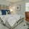 Bedroom with large bed, ensuite. queen bed and nightstands.